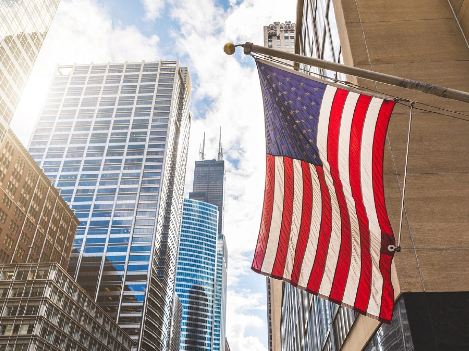 Close up of an American flag with a cityscape background.