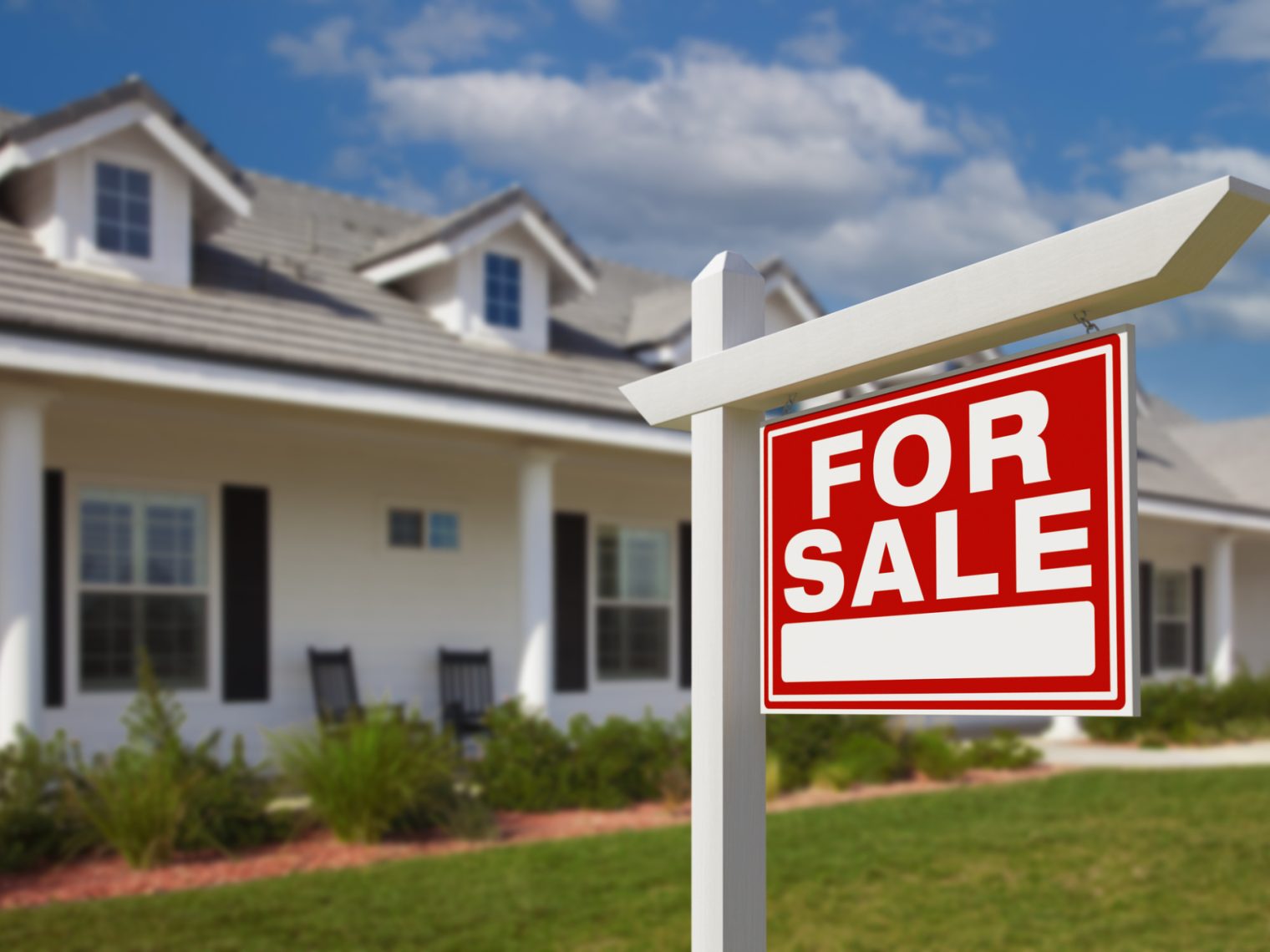 A house with a for sale sign out front.